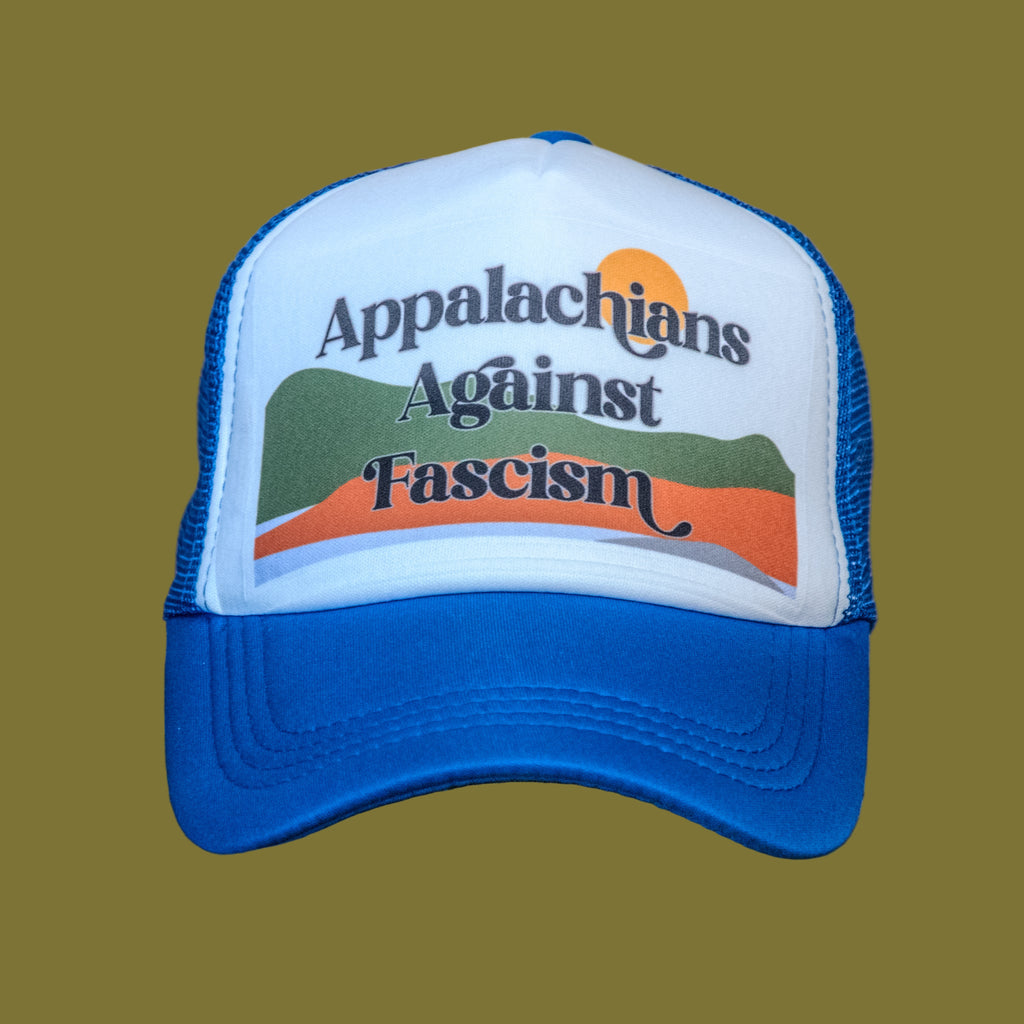 Blue and white cap with 'Appalachians Against Fascism' text on a wooden surface.