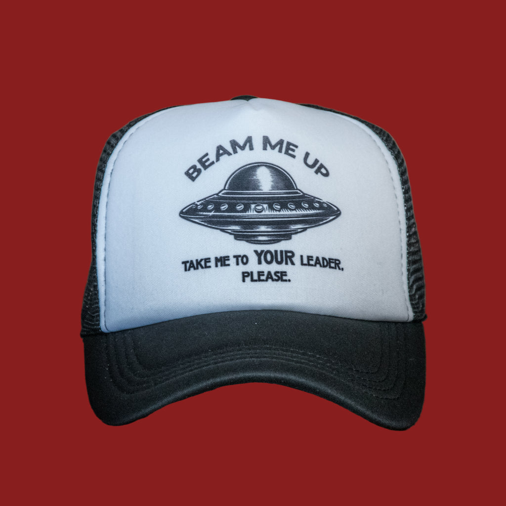 Trucker hat with UFO design and text on a wooden surface