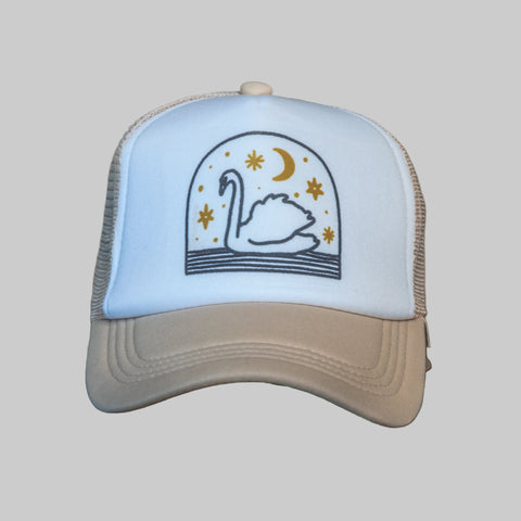 Trucker hat with swan design on a wooden surface